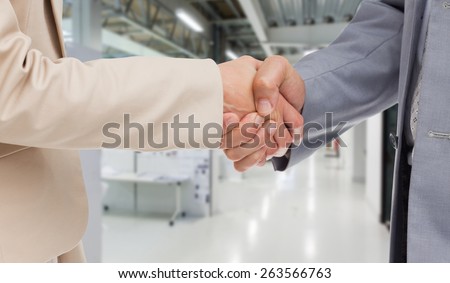 Close up of people shaking hands against college hallway