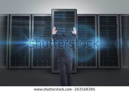 Businessman standing and pushing with hands against server towers