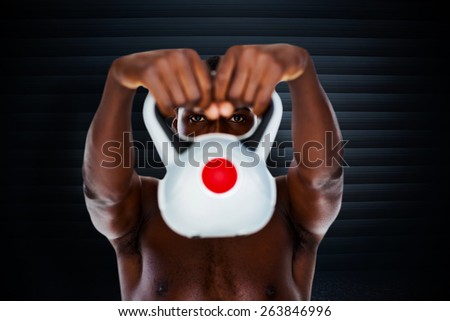 Shirtless fit young man lifting kettle bell against black background