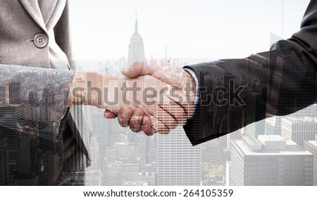 Close up of two businesspeople shaking their hands against city skyline
