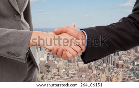Close up of two businesspeople shaking their hands against new york