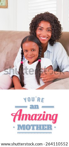 mothers day greeting against pretty mother sitting on the couch with her daughter smiling at camera