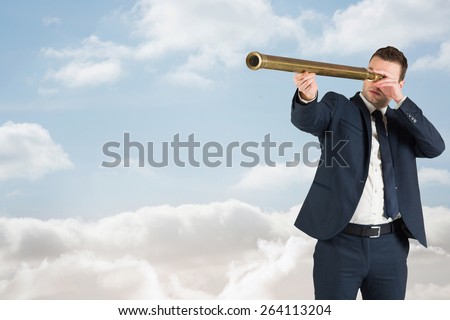 Businessman looking through telescope against cloudy sky