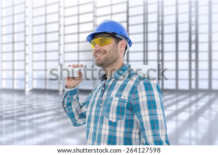 Smiling architect looking away while holding blueprint against room with large window overlooking city