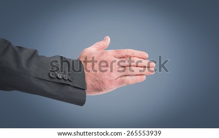 Businessman reaching hand out against blue