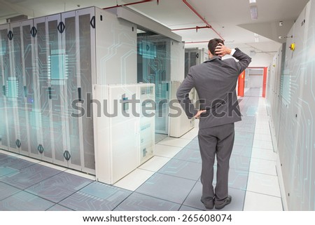Young businessman standing back to camera scratching his head against data center