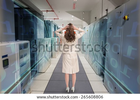 Businesswoman with hands on head standing back to camera against black background with shiny hexagons