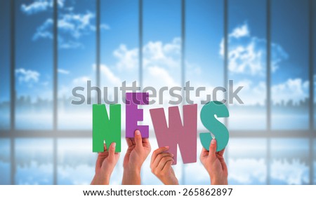 Hands holding up news against room with large window looking on city skyline