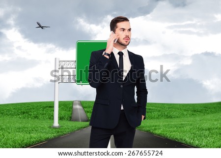 Serious businessman hand in pocket phoning against road leading out to the horizon