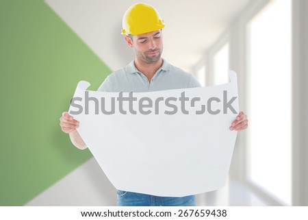 Architect reading plan against modern white and green room with window