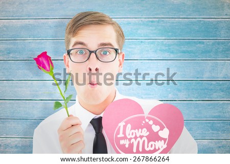 Geeky hipster holding a red rose and heart card against wooden planks