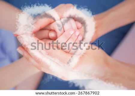 cloud heart against mother and daughter touching hands