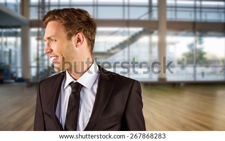 Young handsome businessman looking away against fitness studio