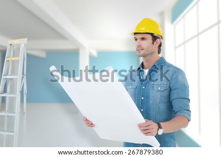 Architect holding blueprint in house against modern blue and white room