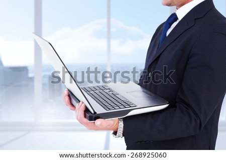 Businessman with watch using tablet pc against bright white room with windows