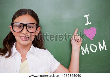 Cute pupil pointing against green chalkboard