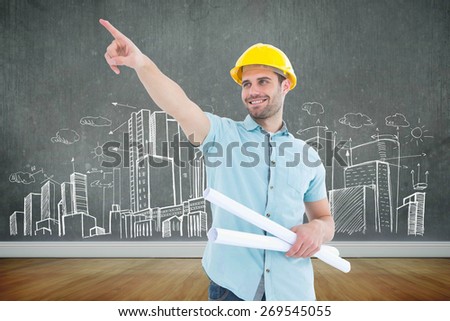 Male architect with blueprints pointing away against room with wooden floor