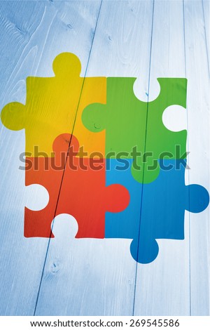 Autism awareness jigsaw against bleached wooden planks background