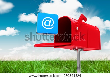 Red email postbox against field and sky