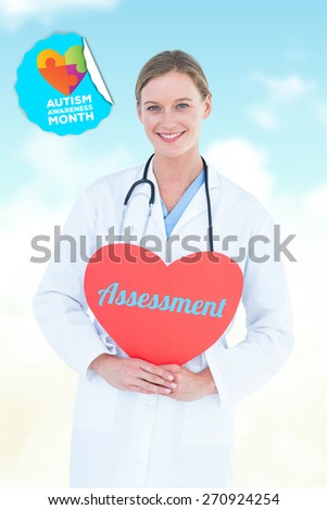 The word assessment and doctor holding red heart card against blue sky