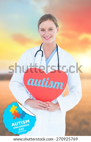 The word autism and doctor holding red heart card against countryside scene