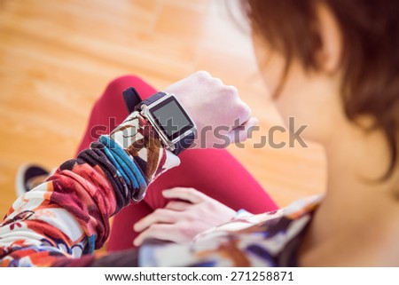 Slim woman looking at her smart watch at home