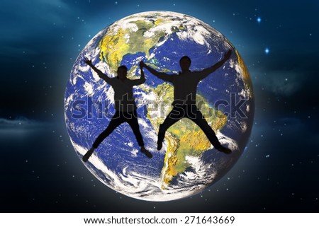 Couple jumping and holding hands against stars twinkling in night sky
