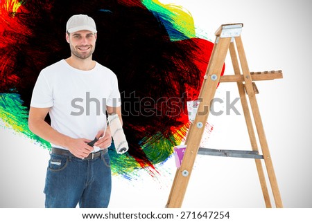 Man holding paint roller while standing by ladder against red green black yellow and blue paint