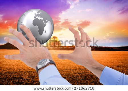 Businessman holding something with his hands against countryside scene