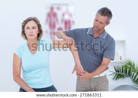 Woman stretching her arm with her doctor in medical office