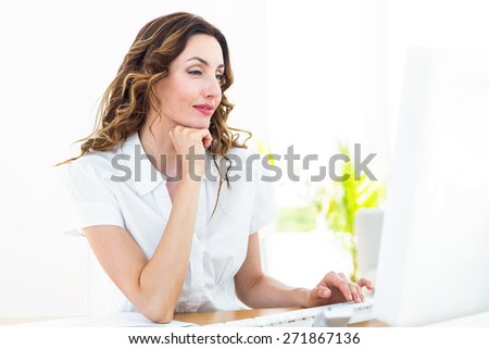 Smiling businesswoman working with her computer on white background