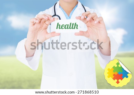 The word health and doctor holding card against sunny green landscape