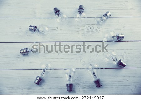 Light bulbs forming frame on wooden table