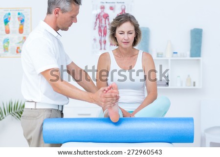 Doctor examining his patients leg in medical office