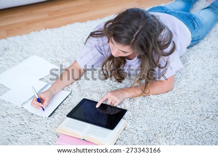 Pretty woman with books and tablet pc at home in the living room
