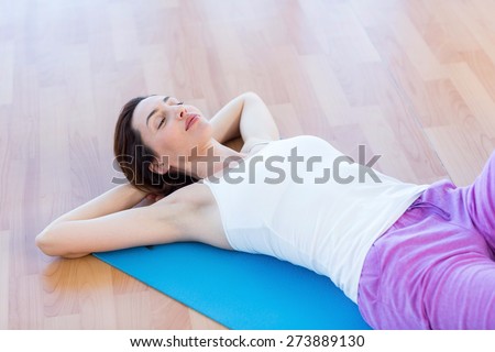 Smiling woman lying on exercise mat in medical office