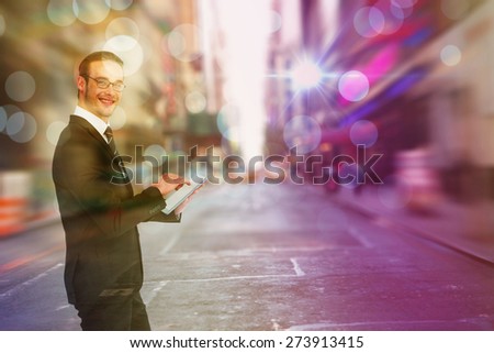 Happy businessman using his tablet pc against blurry new york street