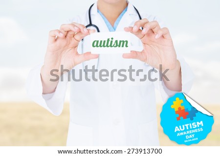 The word autism and doctor holding card against bright brown landscape