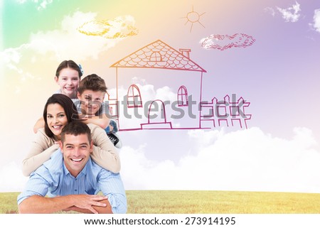 Family lying on top of each other against blue sky over green field