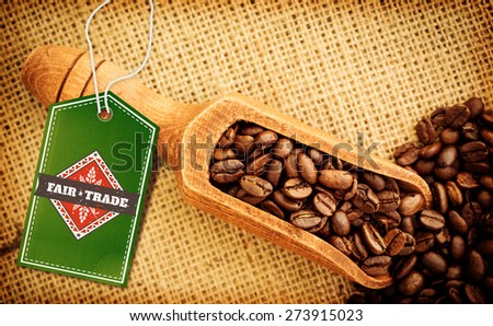 Fair Trade graphic against wooden shovel full of coffee beans