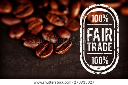 Fair Trade graphic against dark blurred coffee seeds laid out together on a black table