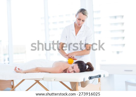 Woman having back massage with massage ball in medical office