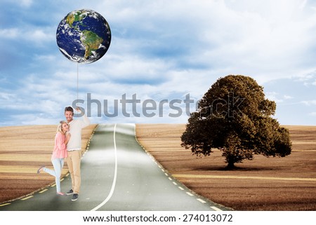 Attractive couple smiling and cheering against road leading out to the horizon