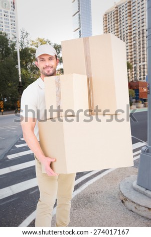 Delivery man carrying cardboard boxes against new york street