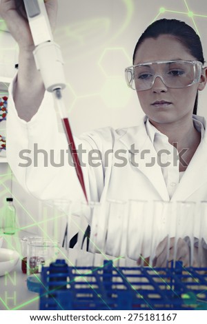 Gorgeous female biologist holding a manual pipette with sample from test tubes against science and medical graphic