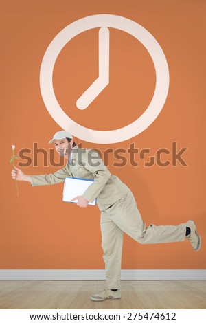 Happy delivery man with clipboard offering flower against room with wooden floor