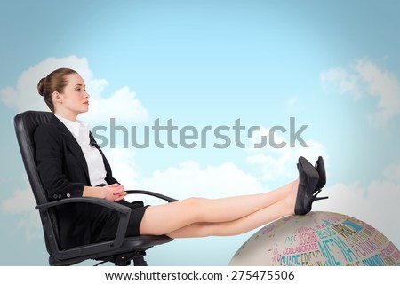 Businesswoman sitting on swivel chair with feet up against blue sky