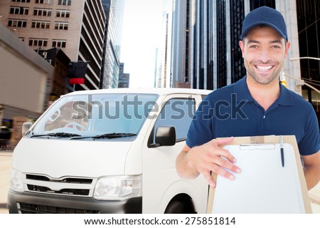 Happy delivery man with package and clipboard against new york street
