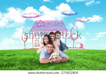 Happy family lying on top of each other with dog against blue sky over green field