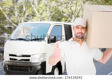 Delivery man with cardboard box gesturing thumbs up against schoolbus on ny street